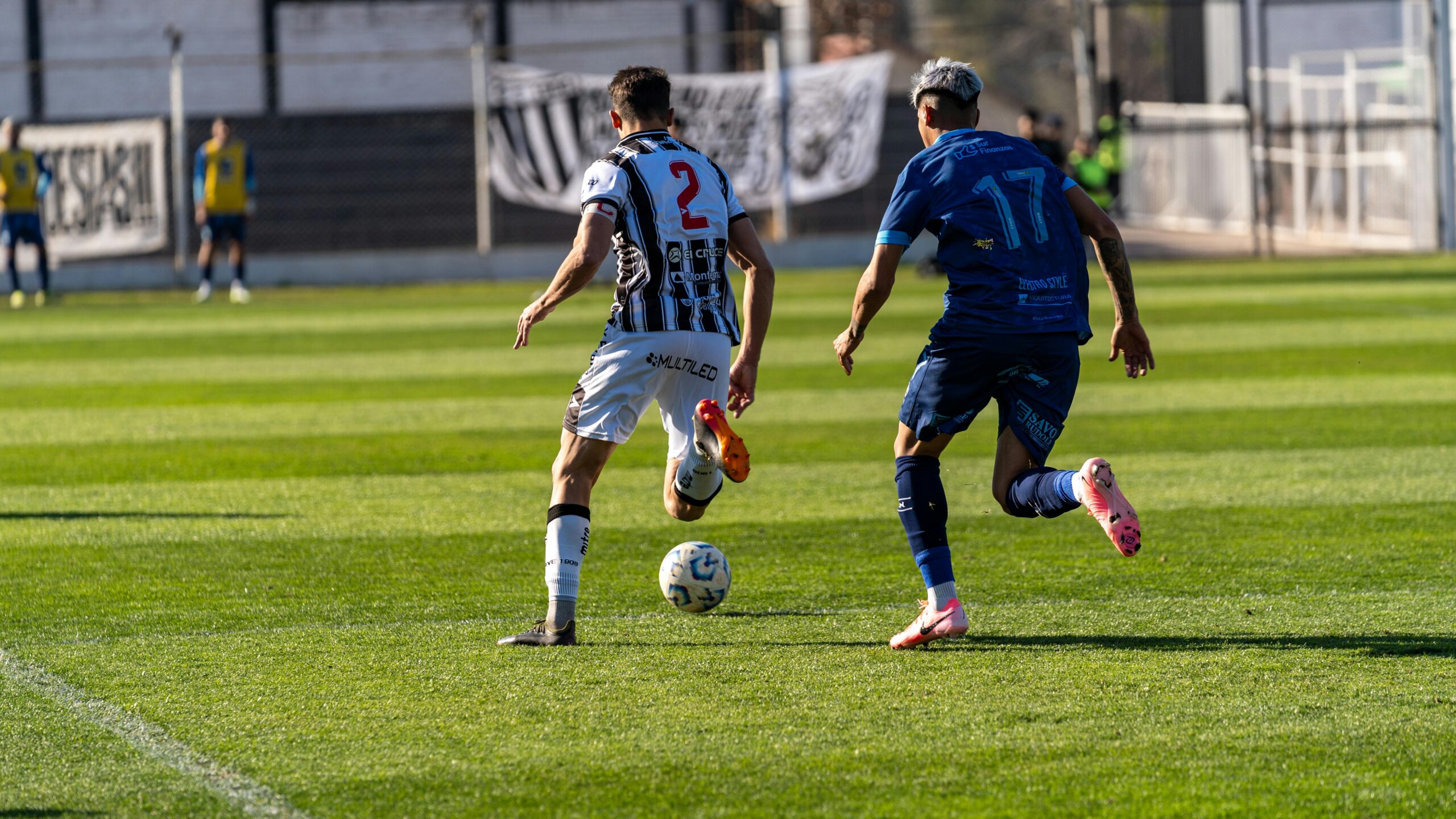 Zwei Fu&Atilde;Ÿballspieler liefern sich auf einem sonnigen Feld einen erbitterten Wettkampf und stellen dabei Athletik und Sportsgeist unter Beweis.
